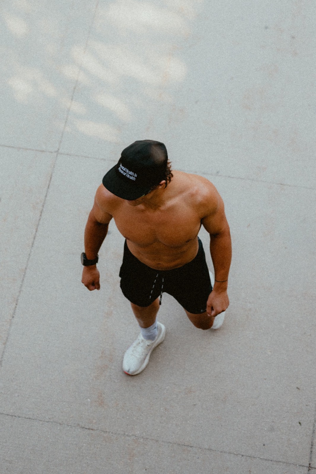 Overhead shot of Logan standing on pavement in running shorts